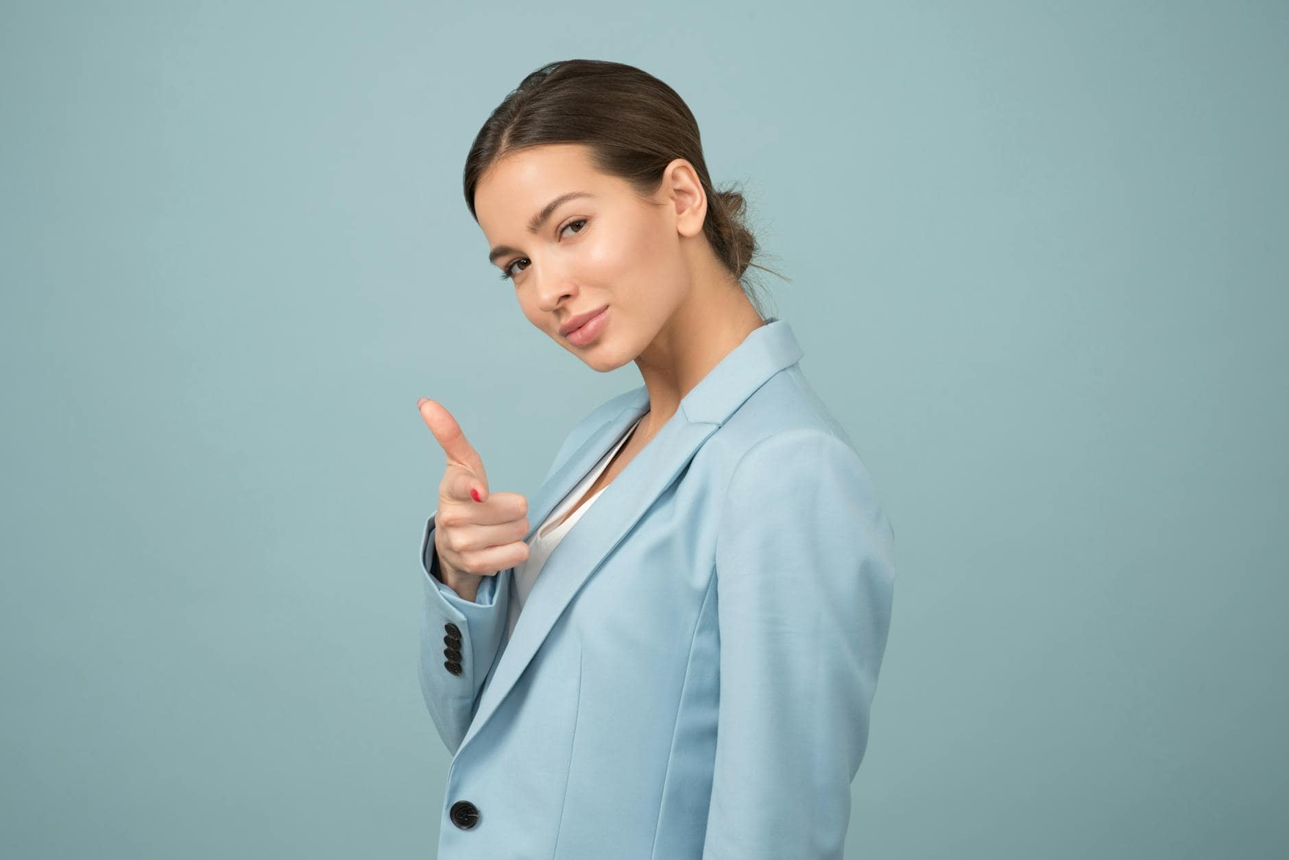 Assertive woman pointing finger, demonstrating confident communication skills.