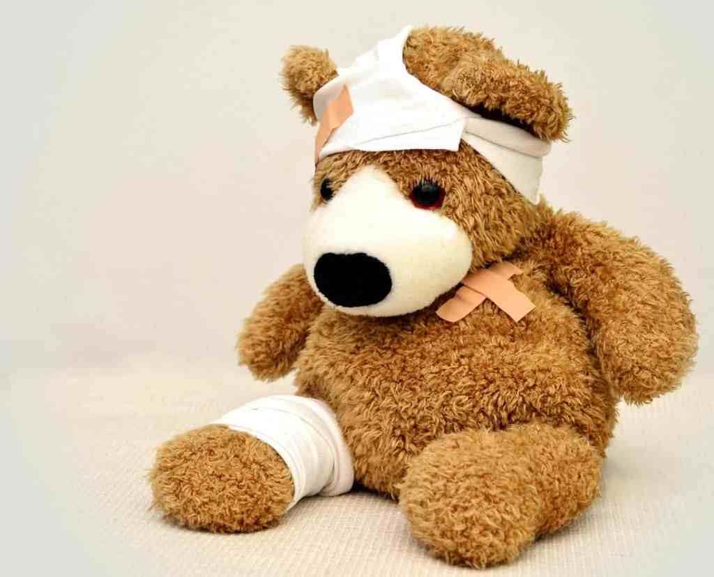 Adorable teddy bear with bandages on its head and paw, symbolizing healing and care in conflict reso.