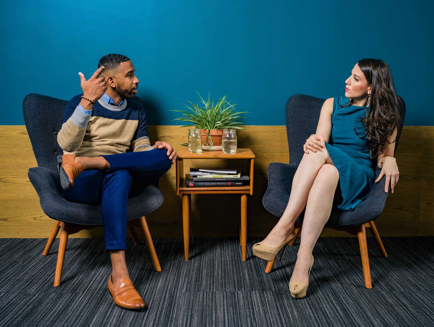 Man and woman having a calm, respectful conversation in a therapy setting.