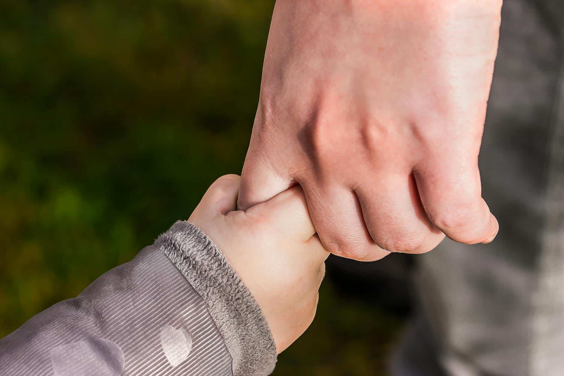 Close-up of two hands holding each other, symbolizing reconciliation and understanding.