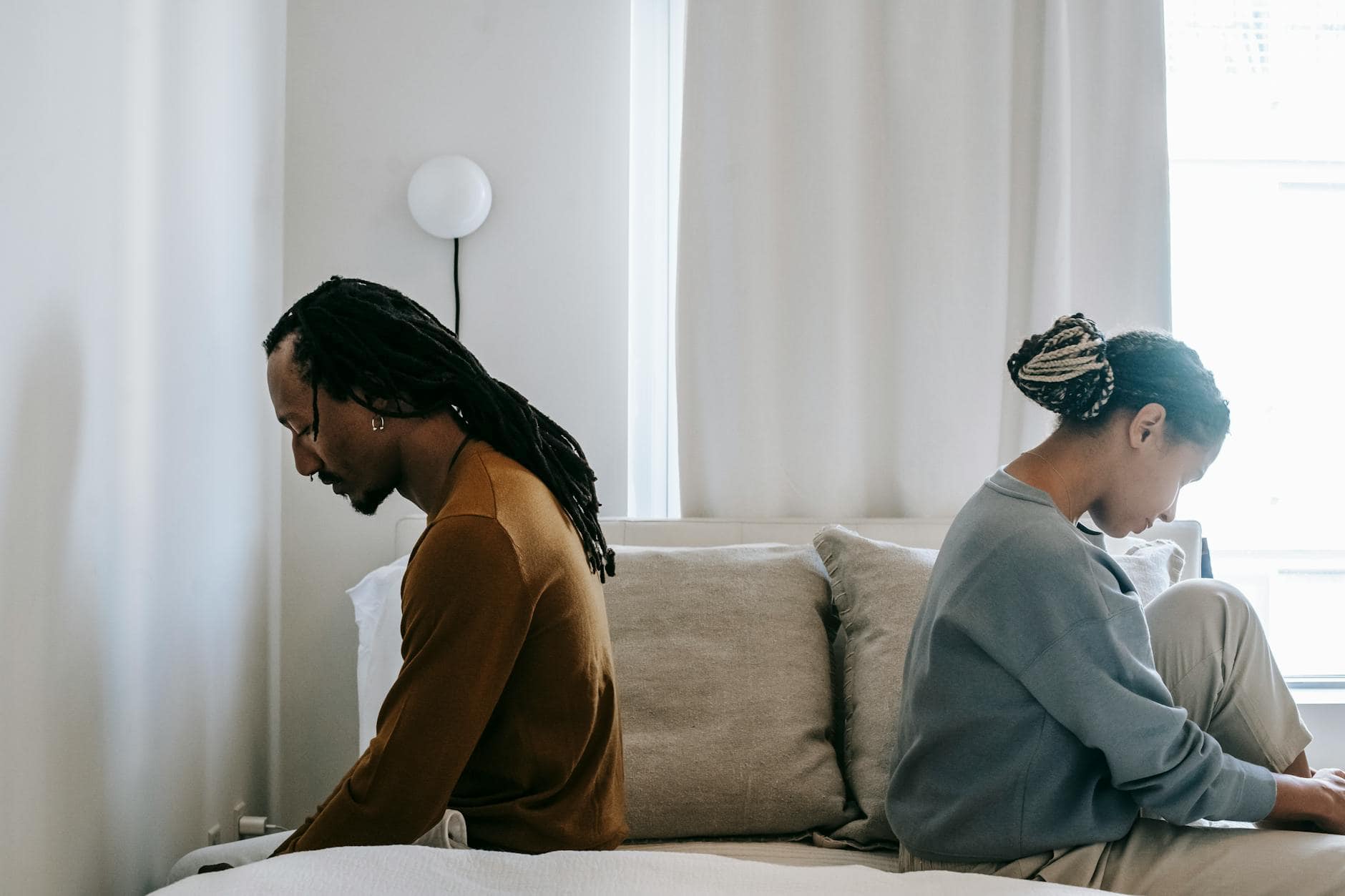 Conflict and grief has damaged this young couple as they sit on their bed, unsure what to do